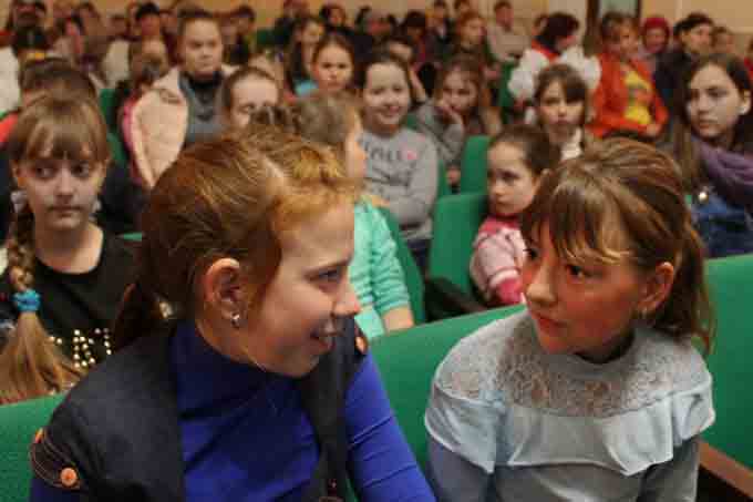 Dos niñas comentan durante la actuación